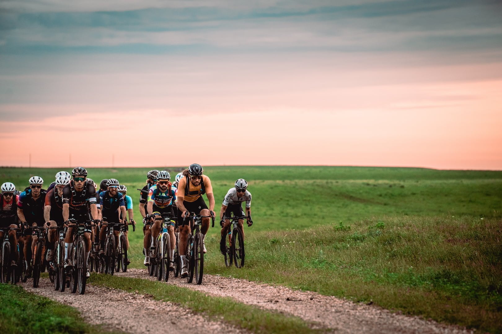 Group of cyclist riding fast on a gravel road.